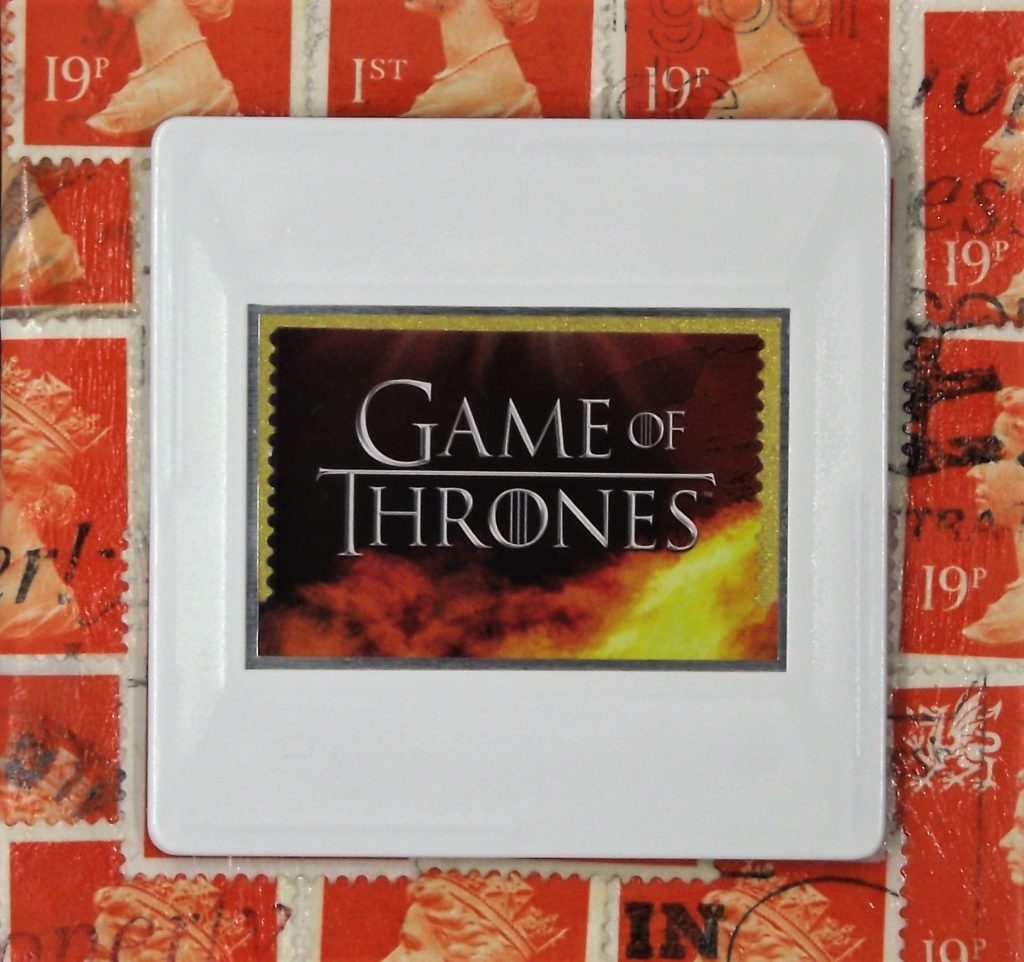 Game of Thrones Brooch title brooch on stamps background

